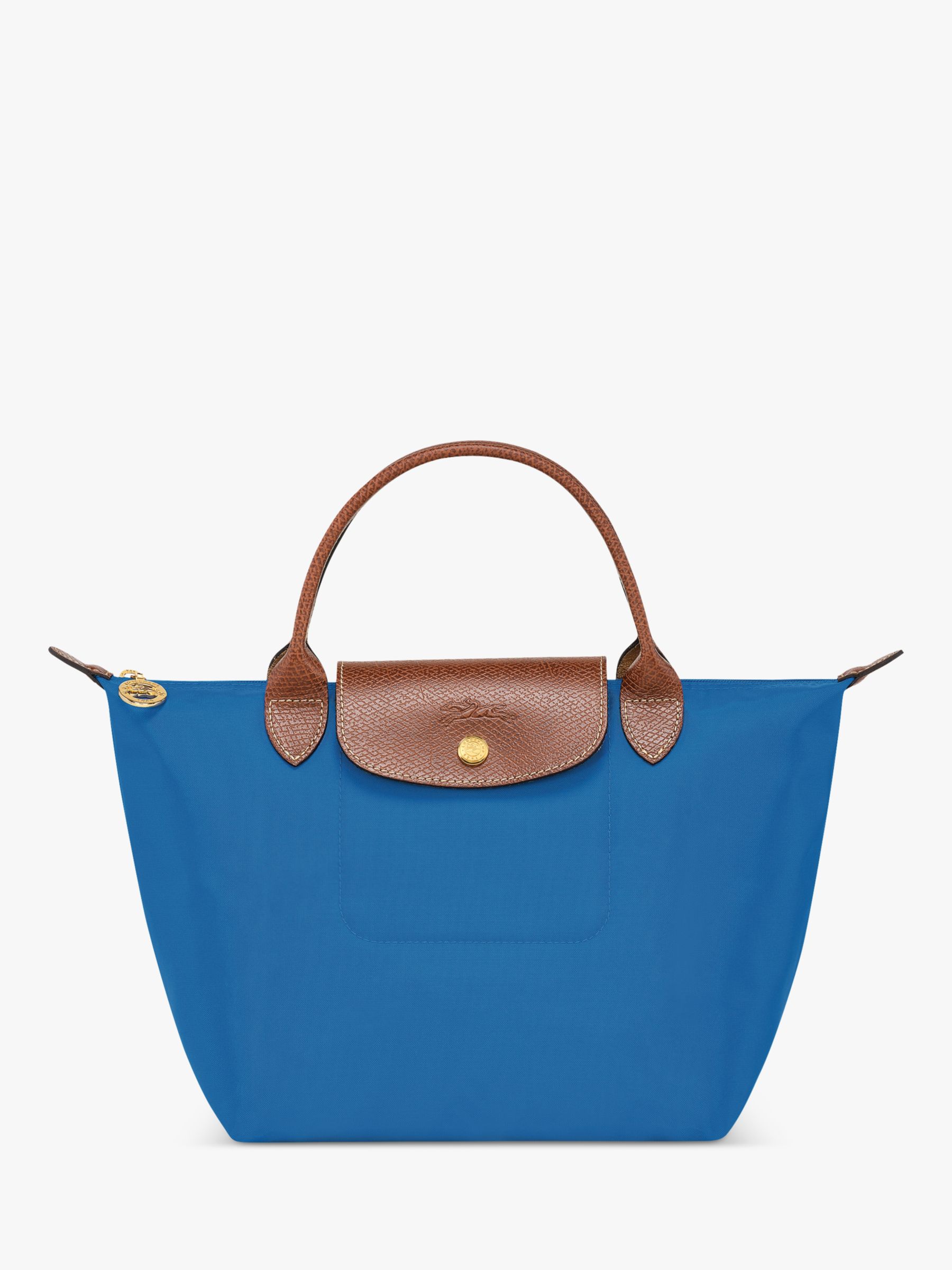 Handbags of the French brand Longchamp, multi-colored, in hands