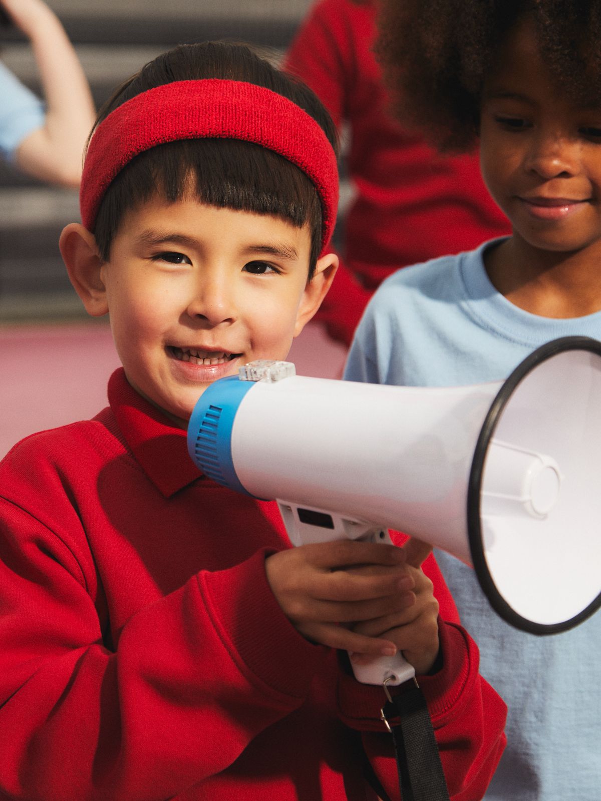 Close up image of a boy holding a loud speaker