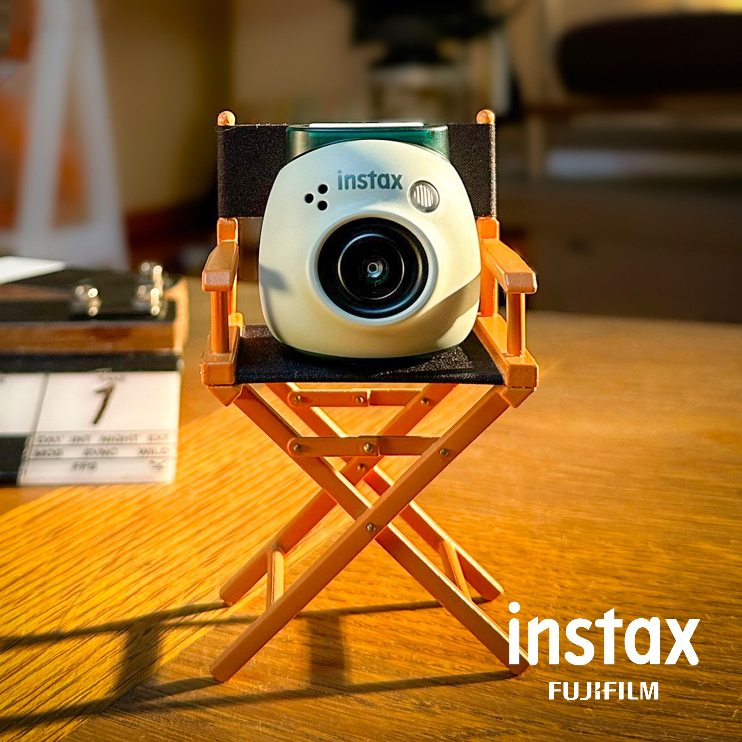 product shot of the instax pal from fugi film sitting on a dictors chair