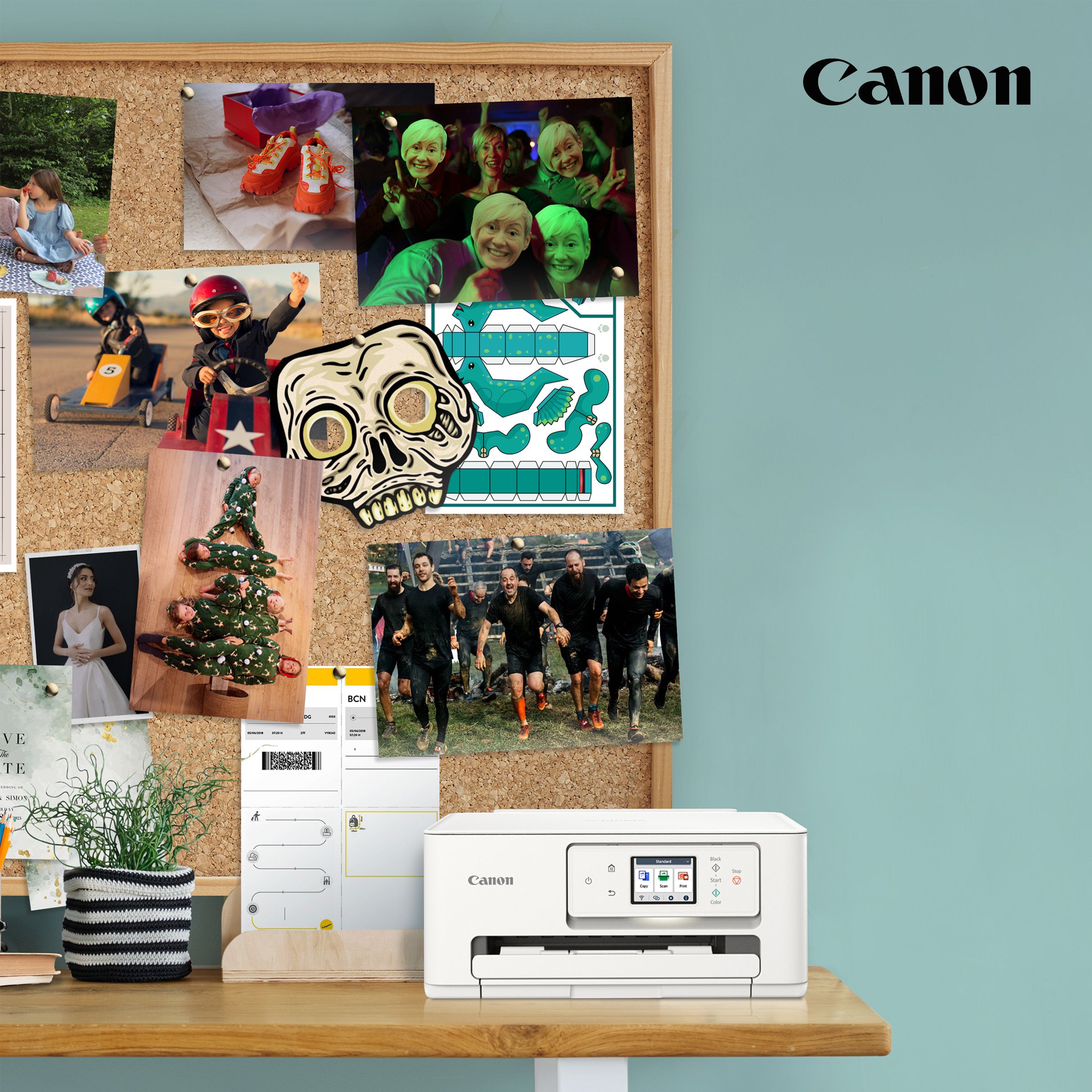 Canon printer next to a backdrop of printed images on a pin board