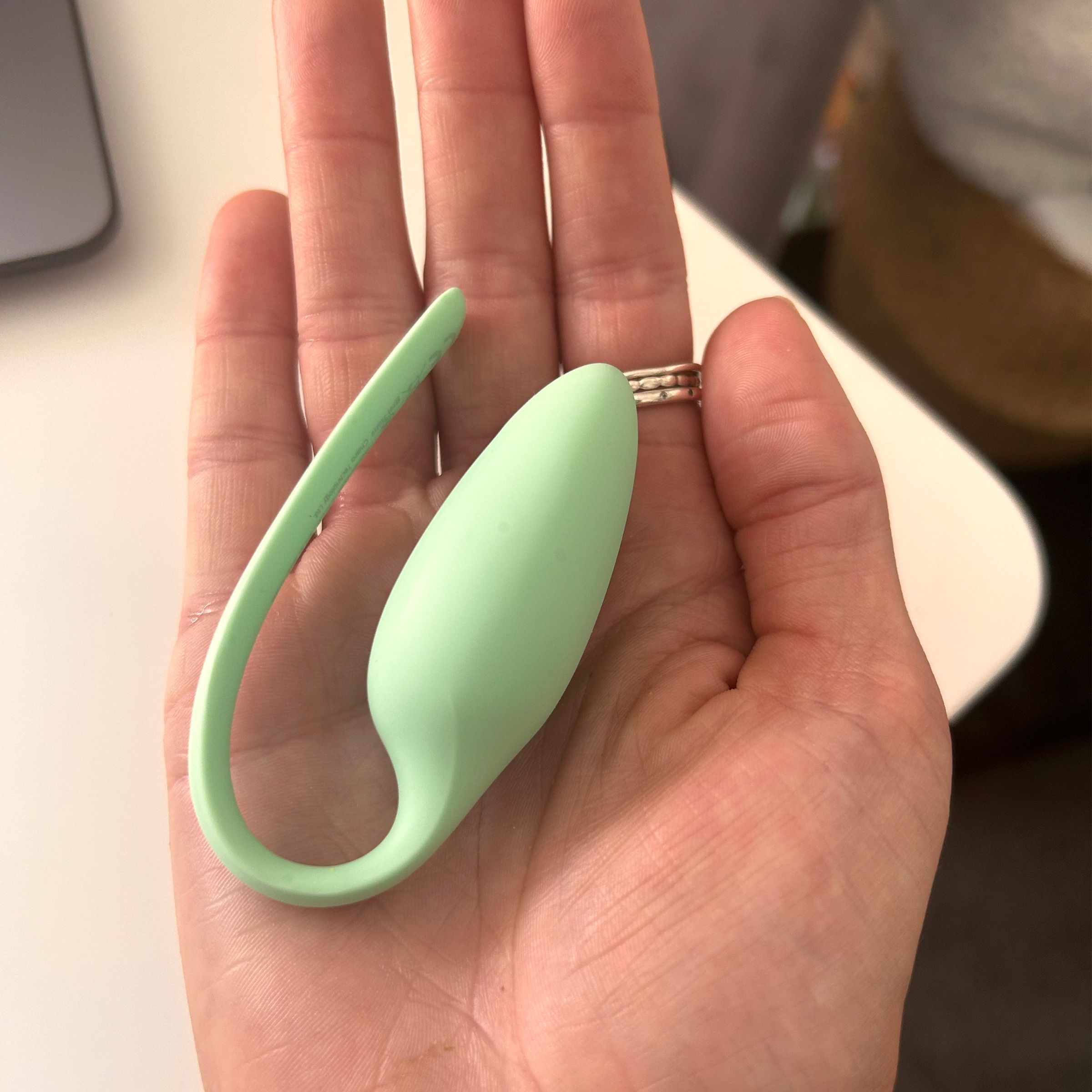 Image of an Elvie Floor Trainer in the palm of a hand to show how small it is