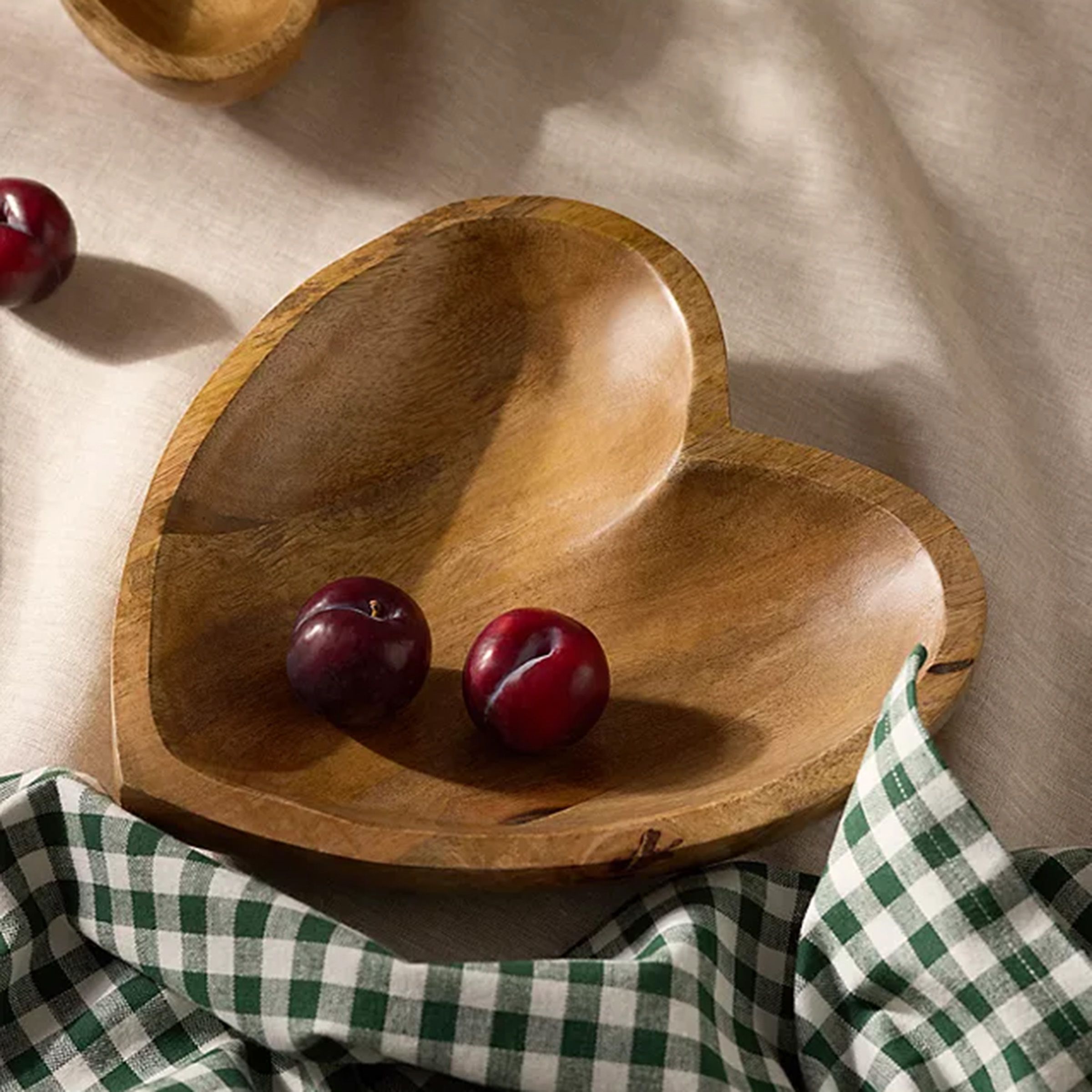 Heart shaped wooden serving bowl with salad in.