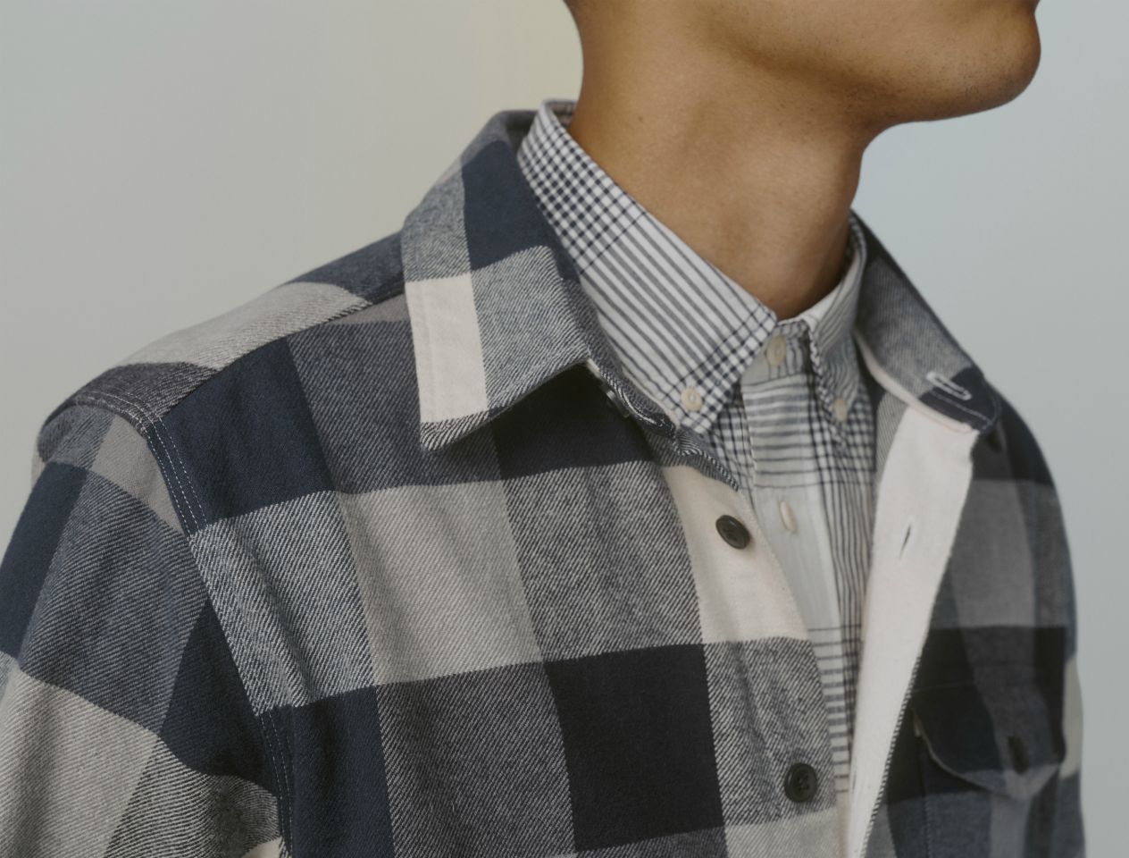 Model wearing two checked shirts