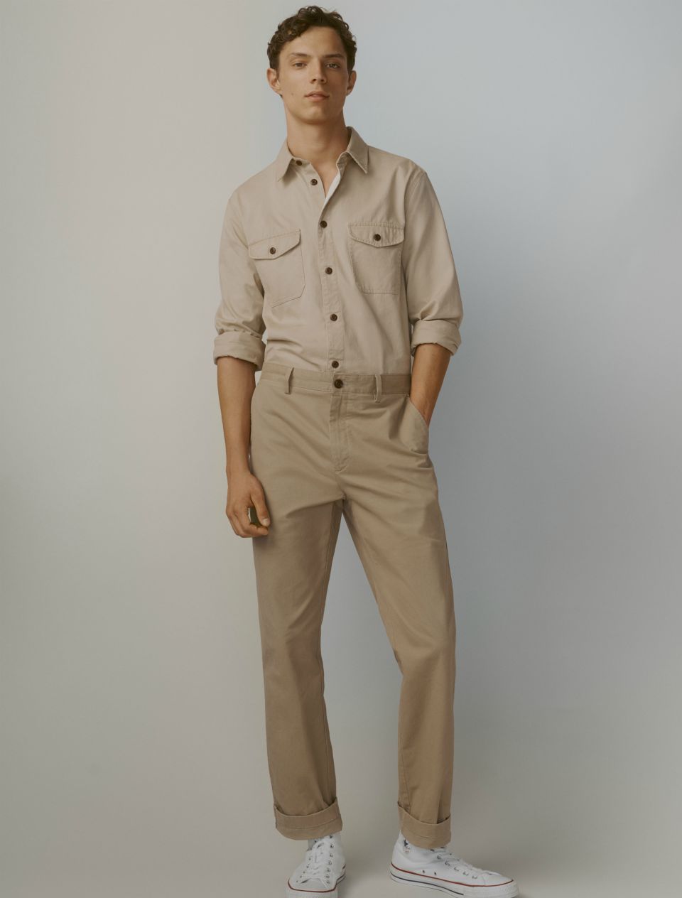 Model in beige chore shirt and beige trousers