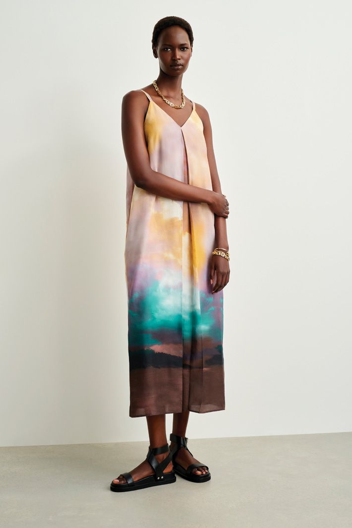 Woman in tie-dye effect strappy dress looking at camera