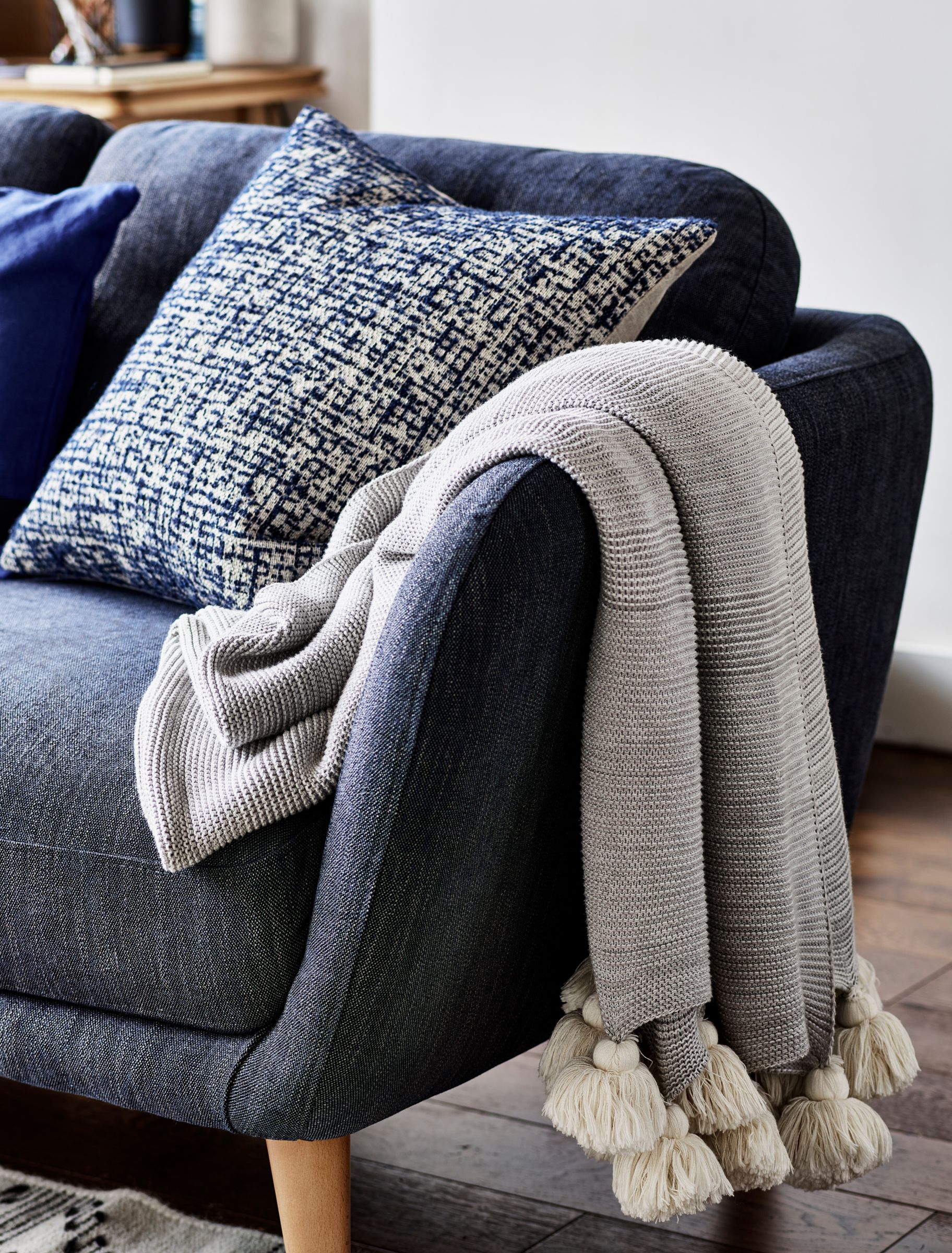 A sofa with grey throw