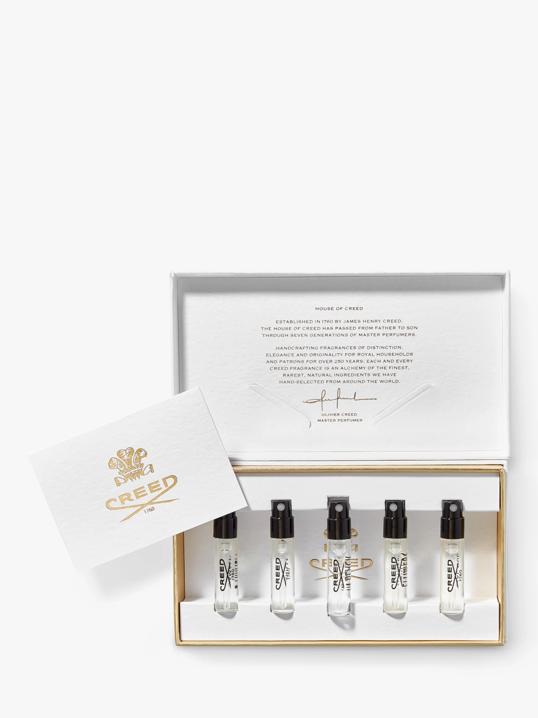 Mini bottles of Creed scents in a gift box, lid open to the side.