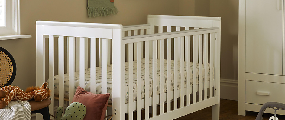 A baby's bed with a wooden headboard