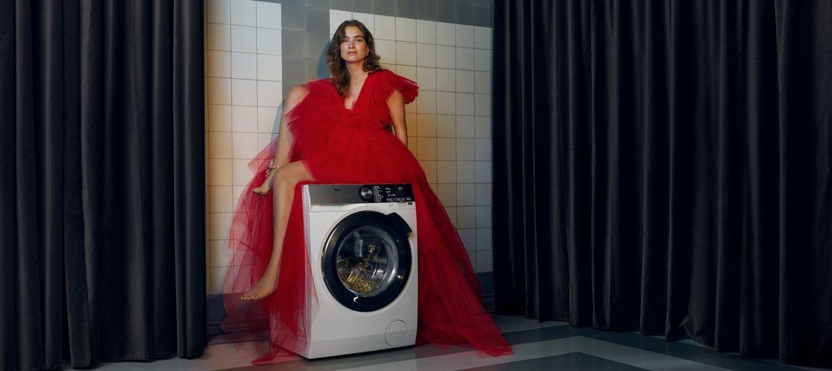 Lady in red dress sitting on a washing machine