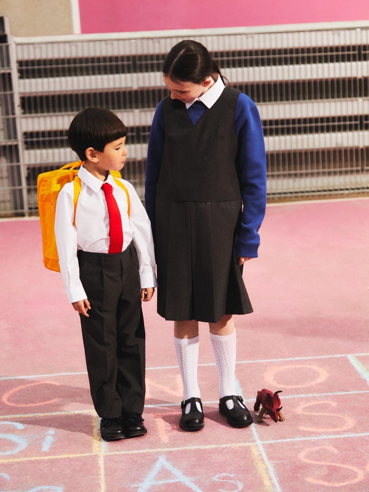 Image of a boy and girl in uniform standing in the playground