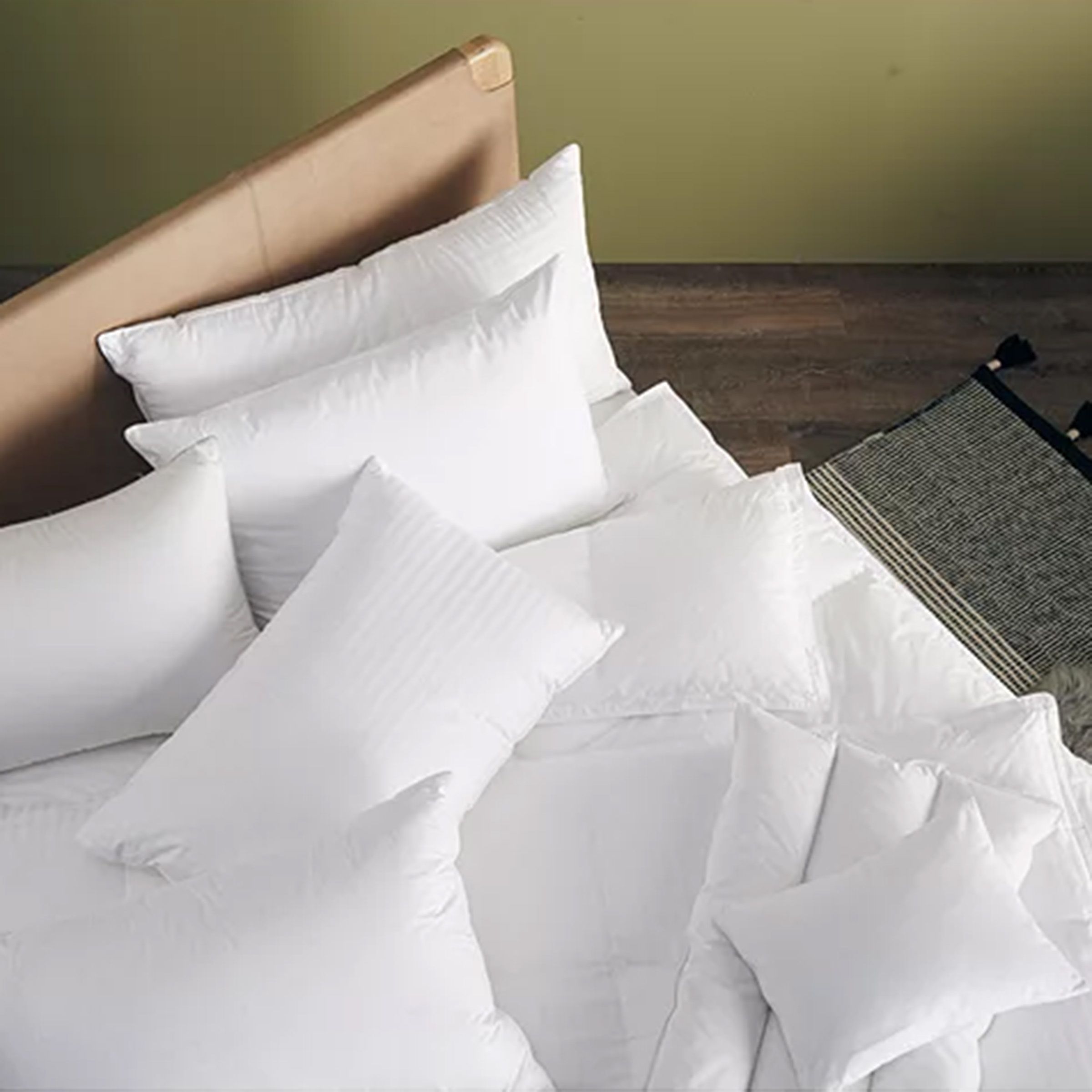 Pile of white pillows on a bed