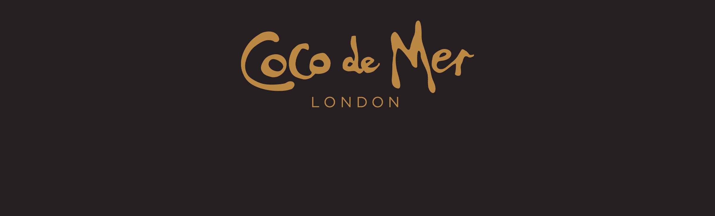 coco de mer banner of a gold logo on a brown background
