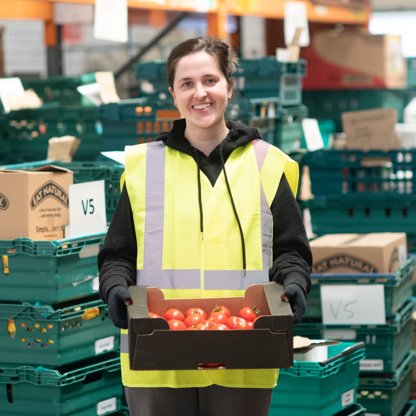  Give a Little Love - FareShare - Women holding a box of tomatoes in warehouse