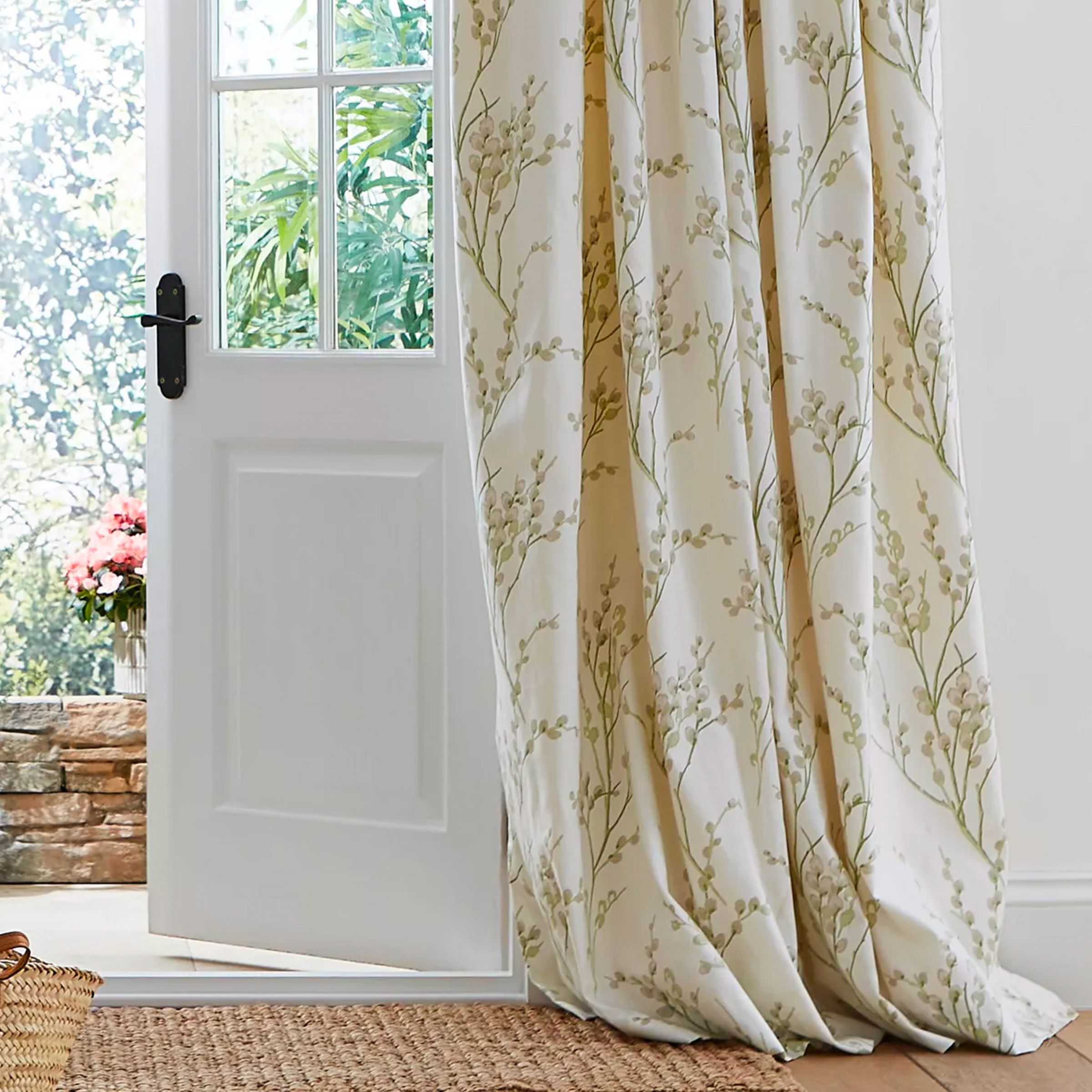 floral off white thermal curtains in a lounge next to a door leading to a garden