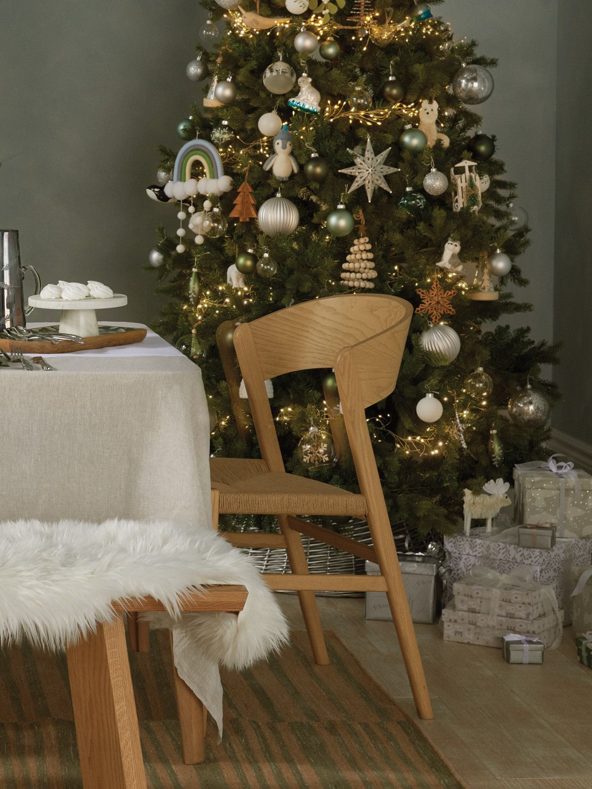 Dining chairs by a table in front of a Christmas tree