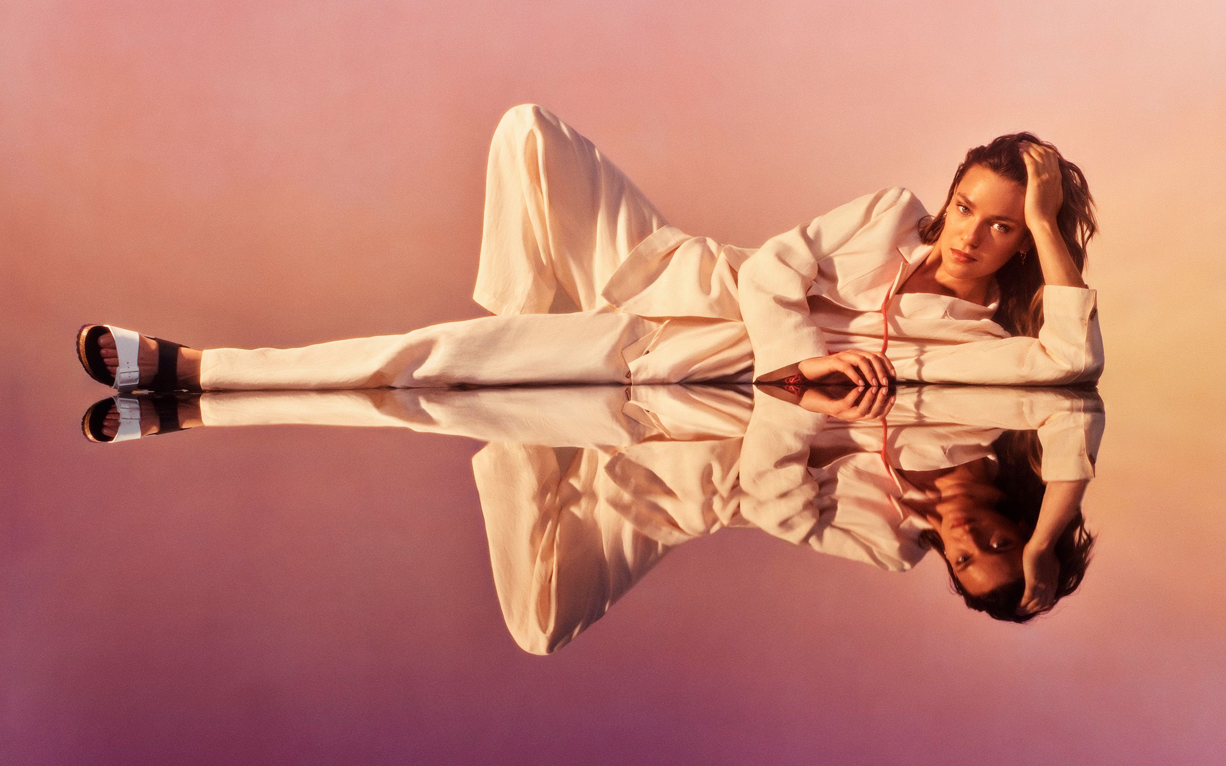 Lady lying on floor with white jumpsuit on