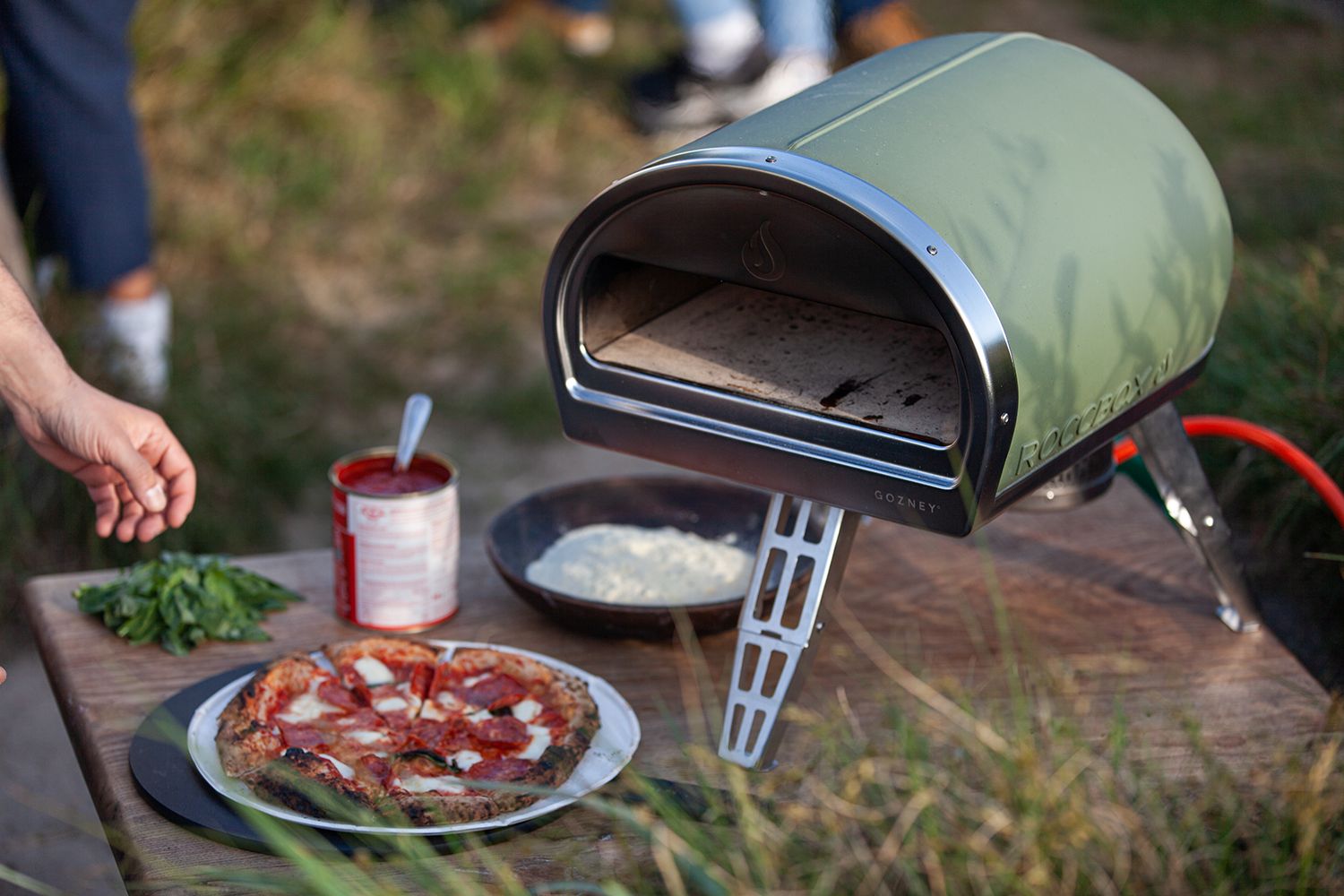 Image of a green Roccbox pizz oven on a garden table