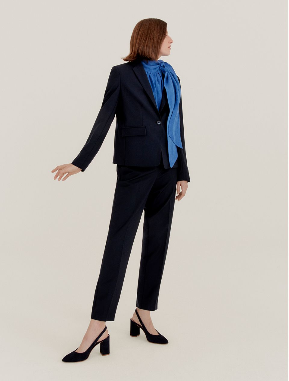 Woman in a black suit and blue blouse