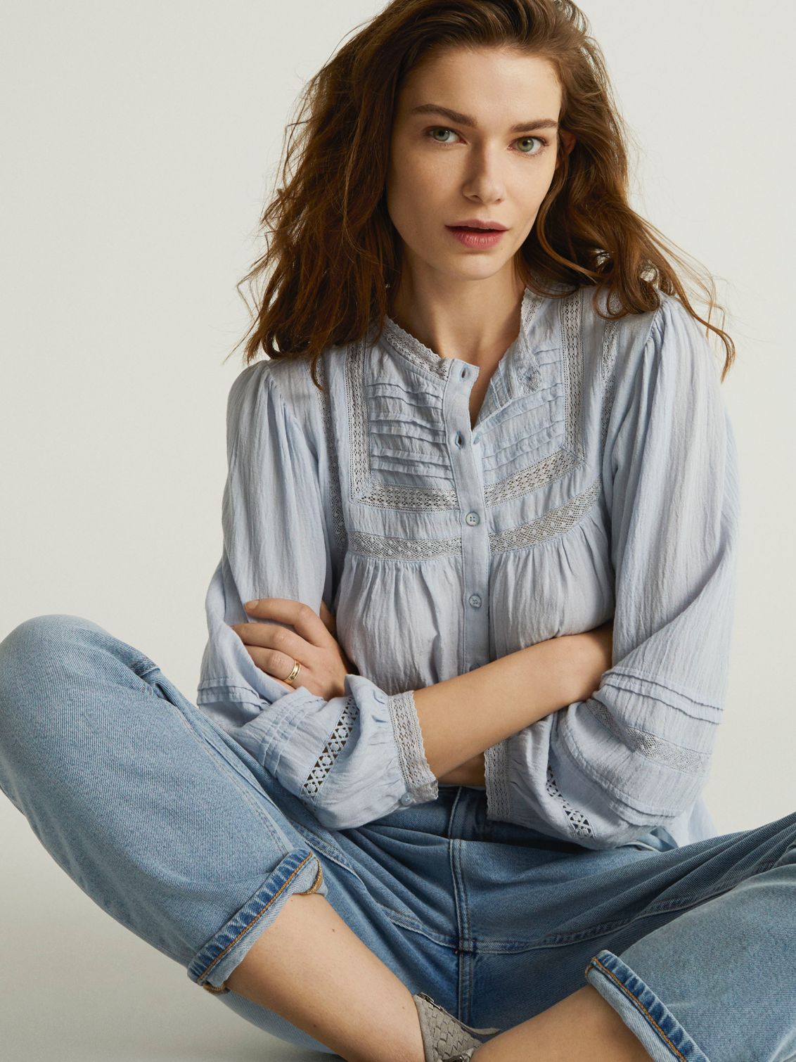 Woman sitting in And/or jeans and top