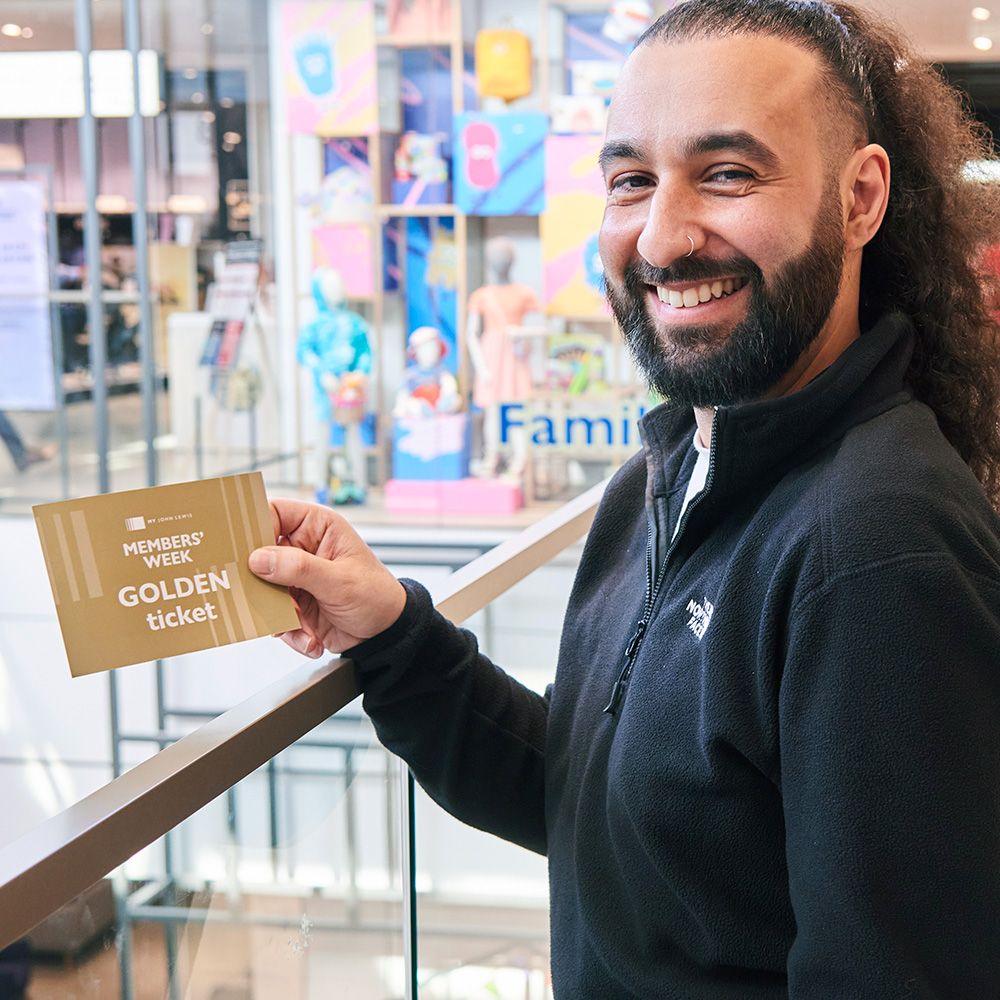 Image of someone holding a golden ticket in a John Lewis store
