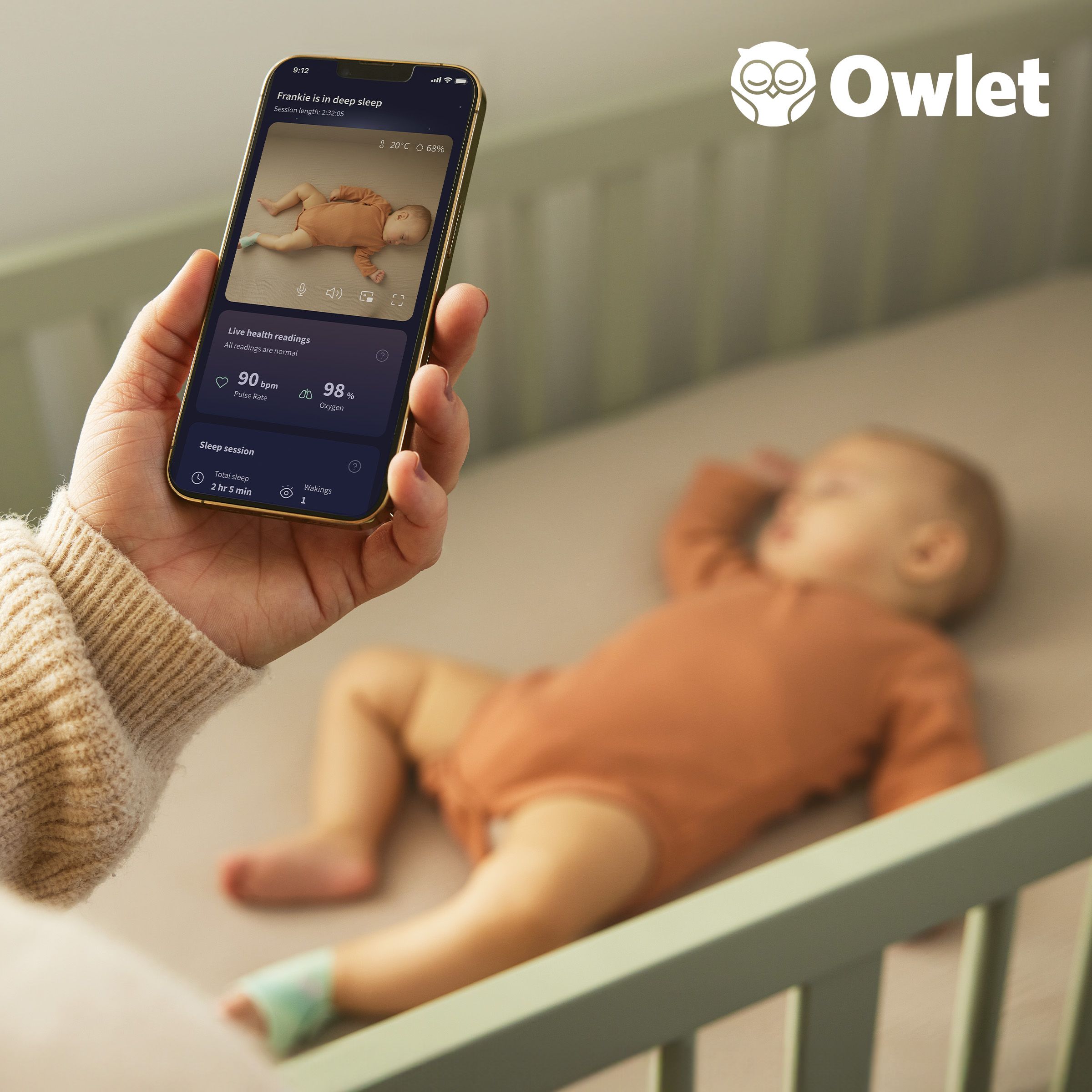 Owlet sock on a baby as a parent takes a video on their phone