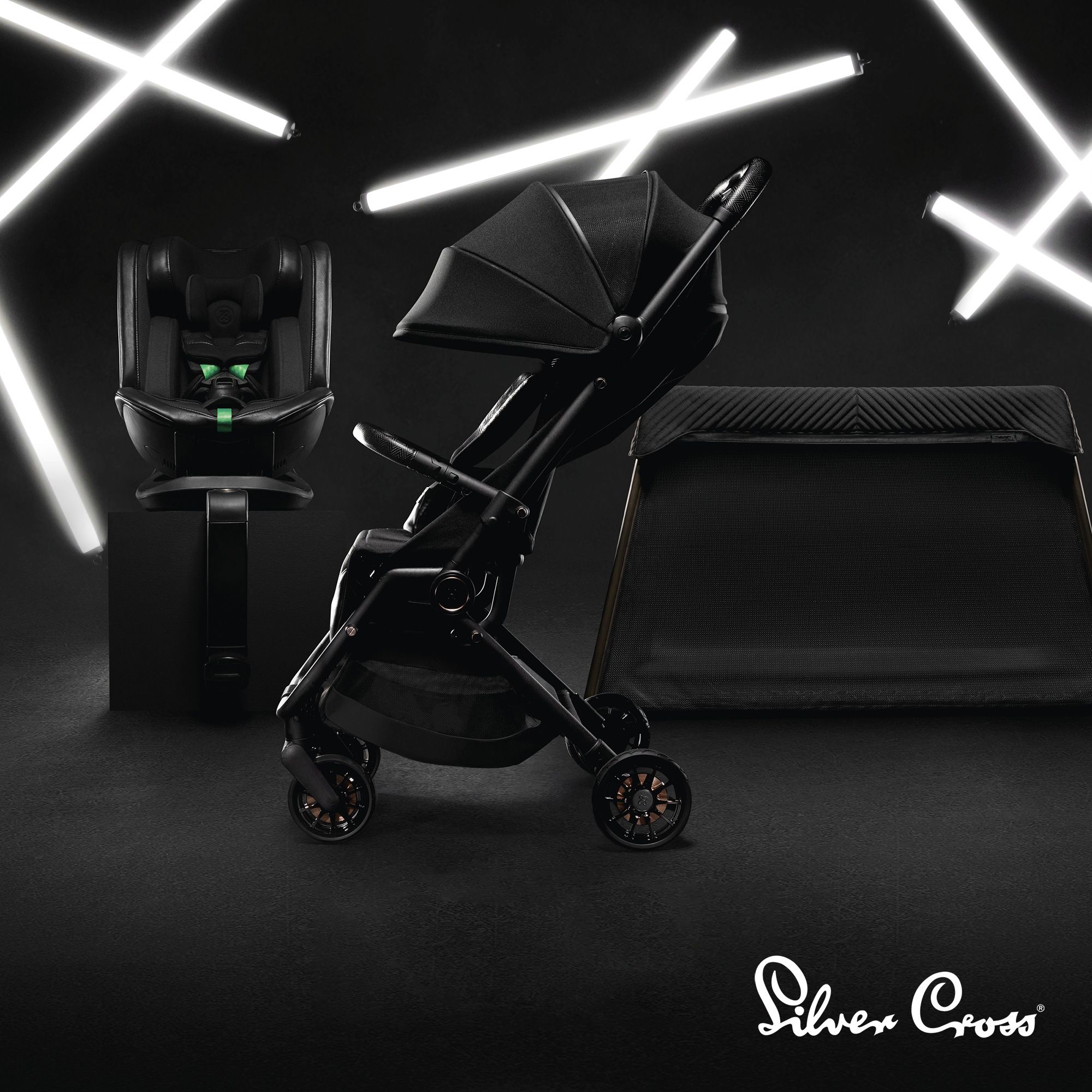 Image of a Silver Cross Pram, with a black background and white neon LED lights behind it