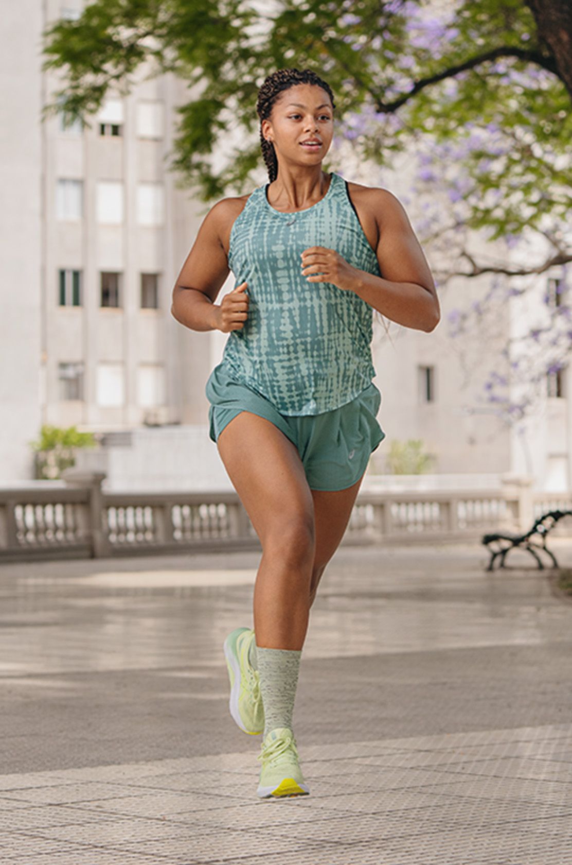 Woman in green Asics running in a city