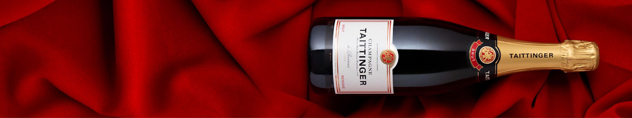 Bottle of Taittinger champagne on silk red background