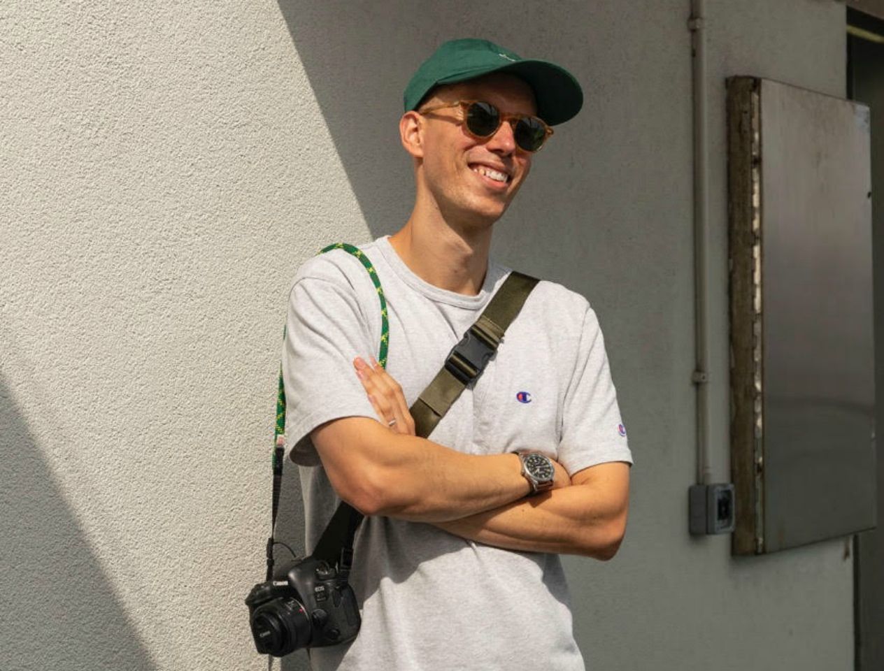 Blogger Matthew Spade wearing a green cap and camera 