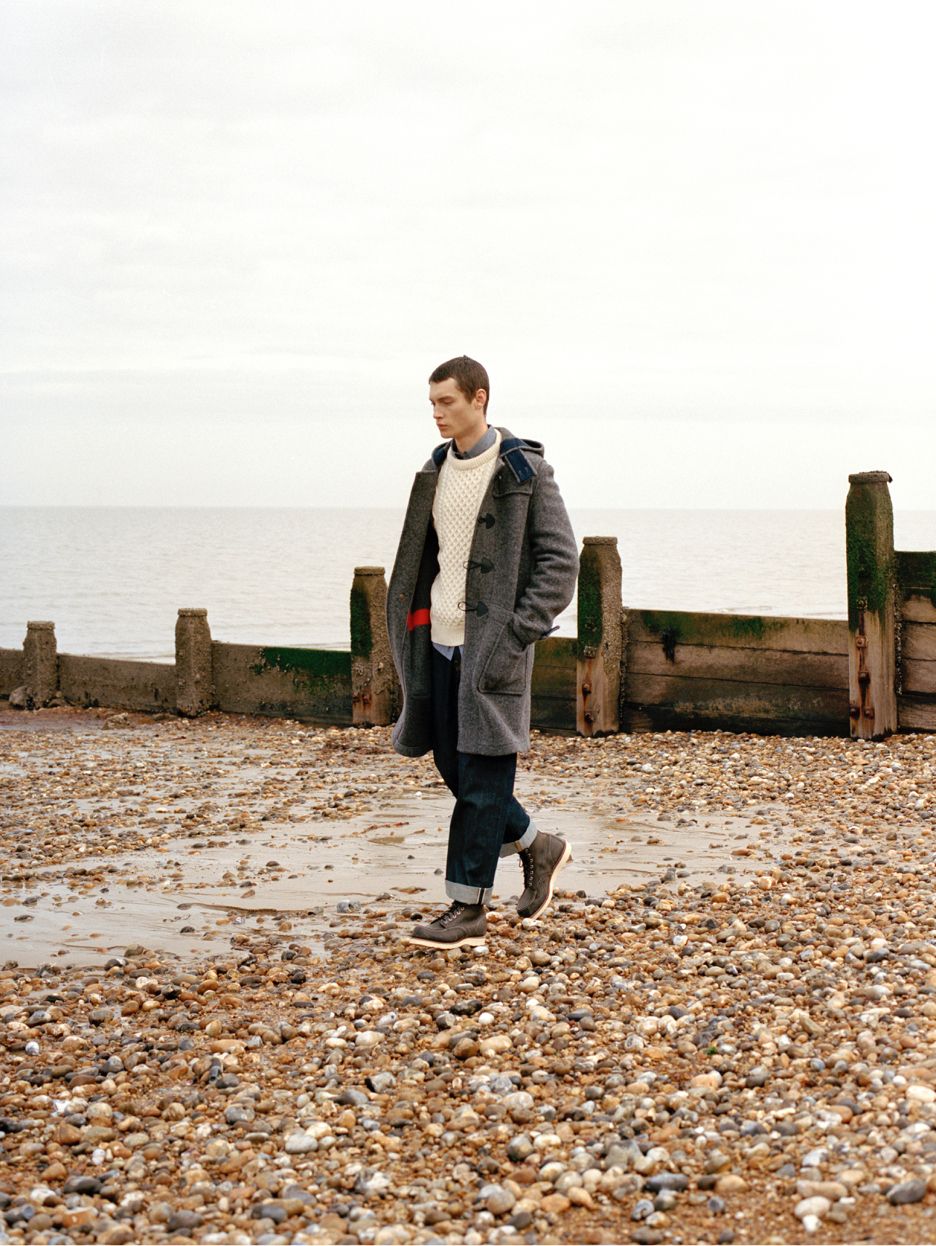 Model on a beach in grey duffle coat