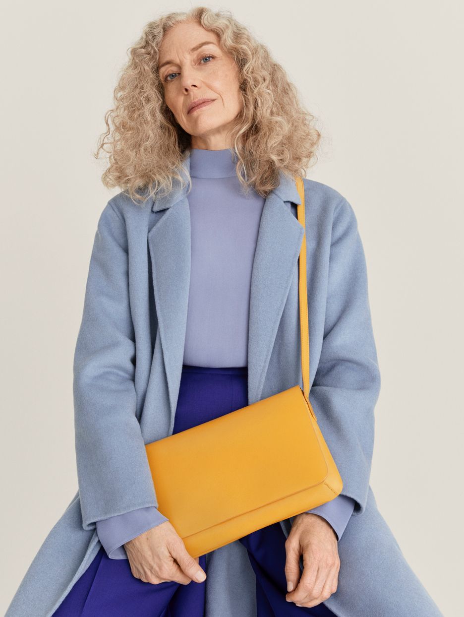 Model Jocelyne Beaudoin in blue coat with yellow handbag