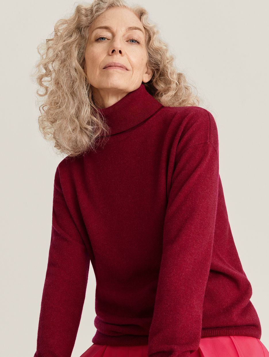 Model Jocelyne Beaudoin in red roll-neck jumper