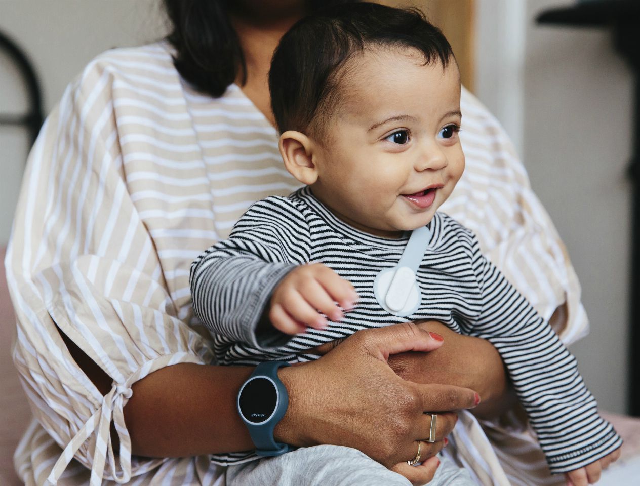 Baby and parent wearing Bluebell smart baby monitor